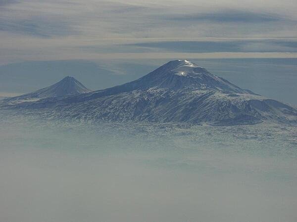 A view of Mount Ararat in western Turkey through the fog. The highest of its two peaks, Greater Ararat, is the tallest mountain in Turkey at 5,166 m (16,949 ft). Although located some 32 km (20 mi) from the Armenian border, the dormant volcano dominates the skyline of Yerevan, Armenia's capital. This photo was snapped after take-off from the Yerevan airport. A view of Mount Ararat in western Turkey through the fog. The highest of its two peaks, Greater Ararat, is the tallest mountain in Turkey at 5,166 m (16,949 ft). Although located some 32 km (20 mi) from the Armenian border, the dormant volcano dominates the skyline of Yerevan, Armenia's capital. This photo was snapped after take-off from the Yerevan airport.
