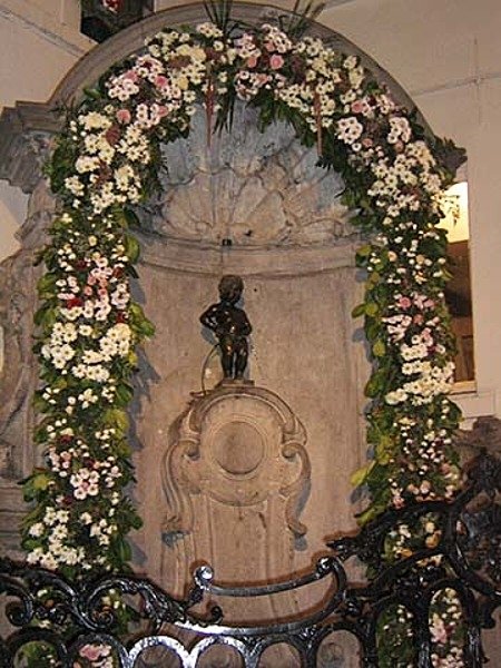 Manneken Pis is a landmark 61 cm (24 in) bronze fountain sculpture in the center of Brussels, Belgium, depicting a naked little boy urinating into the fountain's basin. Erected in 1618 or 1619, the current statue is a replica that dates from 1965. The original is preserved in the Brussels City Museum. Manneken Pis is a landmark 61 cm (24 in) bronze fountain sculpture in the center of Brussels, Belgium, depicting a naked little boy urinating into the fountain's basin. Erected in 1618 or 1619, the current statue is a replica that dates from 1965. The original is preserved in the Brussels City Museum.<br />