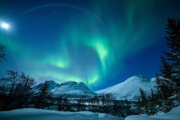 Tromsø, a city situated at 70° north in Norway, is in the middle of the auroral oval, the area with the highest probability of seeing the Northern Lights. The best period to experience the Northern Lights is from early September to early April. During large solar explosions and flares, large quantities of charged particles are thrown from the sun and into deep space. When the particles meet the Earth’s magnetic shield, they are pulled in an oval around the magnetic North Pole where they interact with upper parts of the atmosphere. The Northern Lights are at least 80 km above the Earth’s surface, much higher than clouds. Consequently, a clear sky creates the best backdrop for viewing them Tromsø, a city situated at 70° north in Norway, is in the middle of the auroral oval, the area with the highest probability of seeing the Northern Lights. The best period to experience the Northern Lights is from early September to early April. During large solar explosions and flares, large quantities of charged particles are thrown from the sun and into deep space. When the particles meet the Earth’s magnetic shield, they are pulled in an oval around the magnetic North Pole where they interact with upper parts of the atmosphere. The Northern Lights are at least 80 km above the Earth’s surface, much higher than clouds. Consequently, a clear sky creates the best backdrop for viewing them