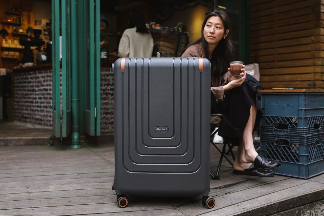 Woman Sitting with Suitcase at Cafe